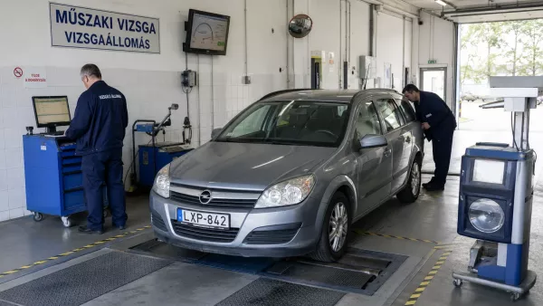 A vizsgaállomáson egy időpontra érkezett autó műszaki vizsgáztatása zajlik.